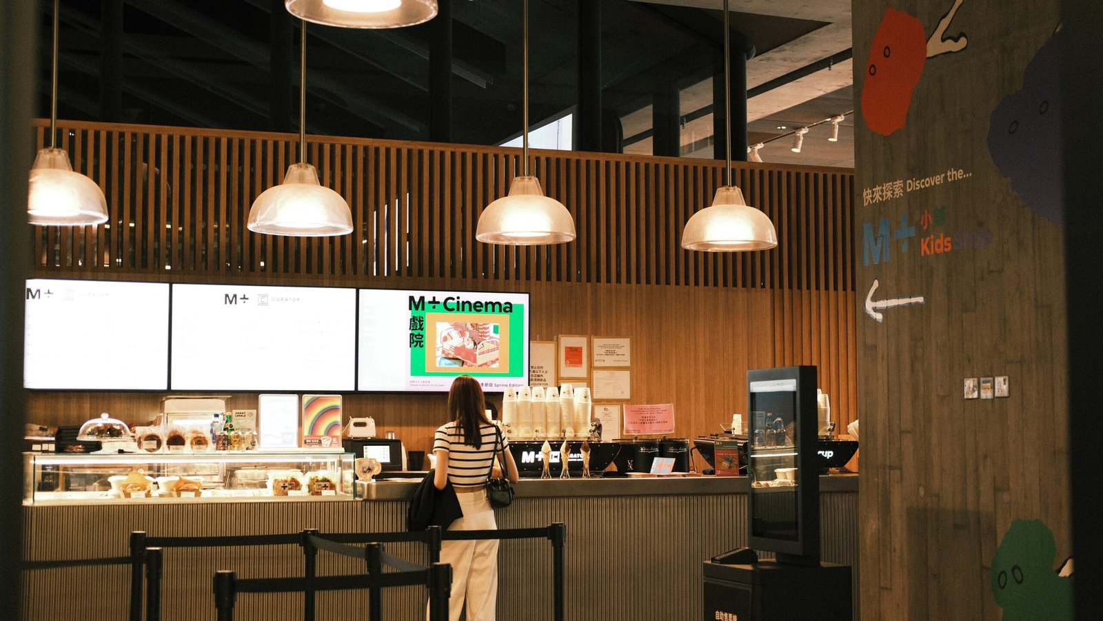 A woman standing in front of a counter in a restaurant