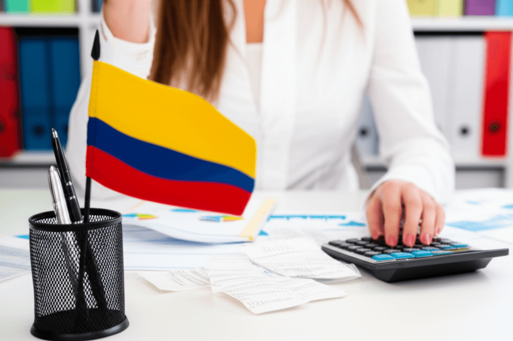 Persona revisando documentos financieros y calculadora para la declaración de renta en Colombia