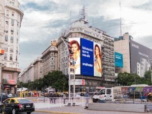 Una calle de la ciudad con una valla publicitaria en el costado