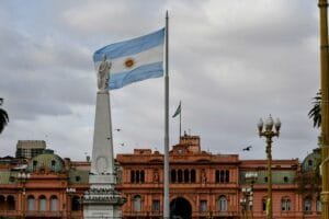 Bandera argentina ondeando cerca de un edificio prominente.